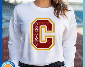 May include: White sweatshirt with a red and gold letter C with the word "Cougar" written vertically inside the C.