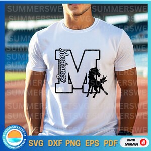 Puede incluir: Camiseta blanca con una letra M negra y una silueta de un caballo. La letra M tiene la palabra "Mustangs" escrita verticalmente dentro de ella.