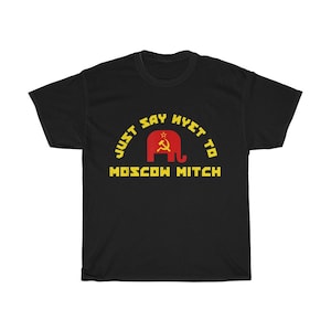 Puede incluir: Camiseta negra con un gráfico amarillo que dice "Just Say Nyet To Moscow Mitch". El gráfico presenta un elefante rojo con una hoz y un martillo.