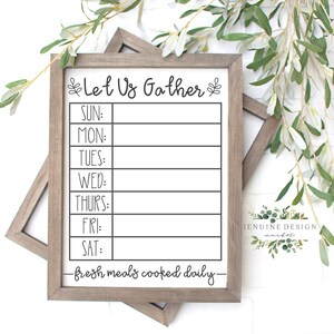 May include: A white framed sign with the text "Let Us Gather" and a weekly meal planner with the days of the week listed: Sunday, Monday, Tuesday, Wednesday, Thursday, Friday, and Saturday. The sign also includes the text "fresh meals cooked daily" and a small logo for "Jenuine Design Market".