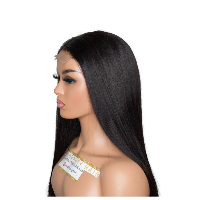 May include: A mannequin head with long, straight, black hair. The hair is styled to fall down the back and sides. The mannequin has long eyelashes and a sticker that says "BOLD BEAUTY HAIR" with a website address.