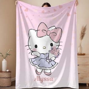 May include: Pink blanket featuring a cartoon cat character with a large pink bow, holding flowers, and wearing a lavender dress. The blanket has a pink heart pattern and the name "Alyssa" is written on it.
