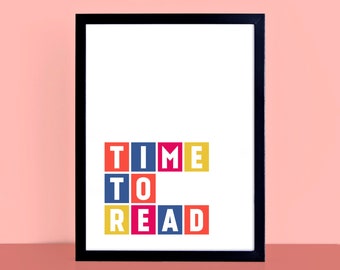 May include: A framed print featuring the text "TIME TO READ" in colourful block letters. The words are arranged in three rows, each word in a different colour. The frame is black, and the background is white.