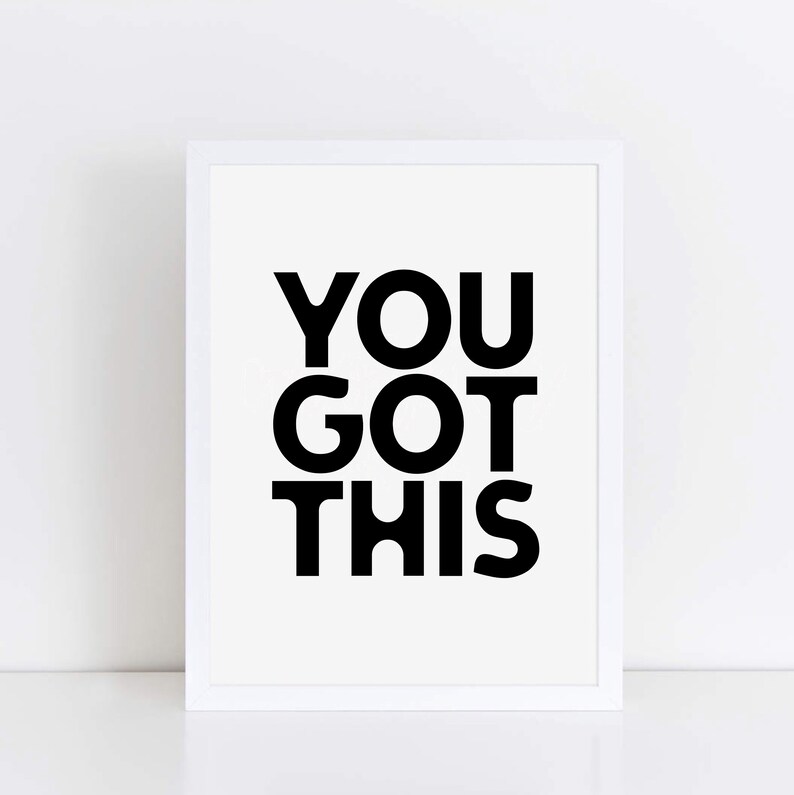 May include: A framed print with the words "YOU GOT THIS" in bold black letters on a white background. The frame is white, and the print is centered, creating a minimalist design.