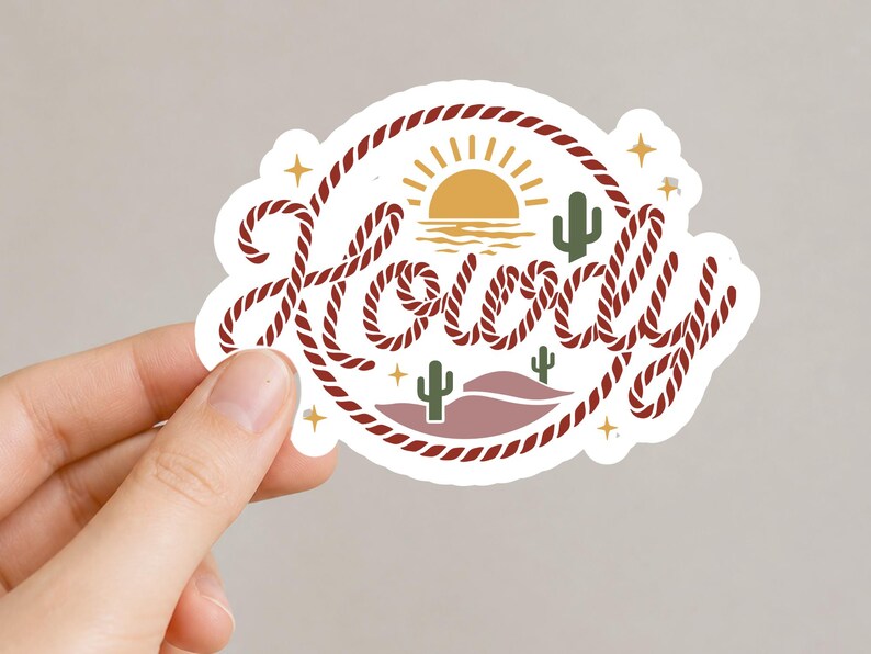 May include: A white sticker with the word "Howdy" in a rope-style font, encircled by a rope border. The design includes a yellow sun, cacti, and stars, evoking a Western theme.