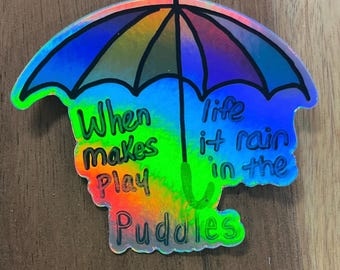 In Pfützen spielen Holographischer Aufkleber | Positives Zitat, spülmaschinenfest