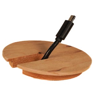 Op de afbeelding: Een houten kabelorganisator met een gesplitst ontwerp om een ​​zwarte USB-kabel vast te houden. De organisator is gemaakt van lichtbruin hout.