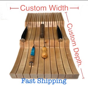 May include: A wooden knife block with multiple slots, holding various knives. The block is light brown and has a curved design. The text "Custom Width" and "Custom Depth" are visible, along with the words "Fast Shipping".