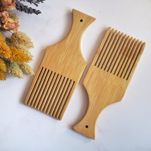 May include: Two wooden combs with a wide tooth design. The combs are made of natural bamboo and have a smooth, polished finish.