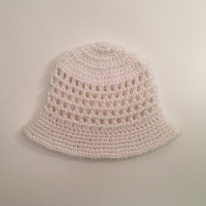 May include: A white crocheted bucket hat with a wide brim and a lacy design.
