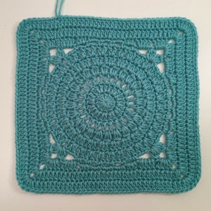 May include: A teal blue crocheted square with a circular design in the center. The square has a border of single crochet stitches and the circle has a repeating pattern of open stitches.