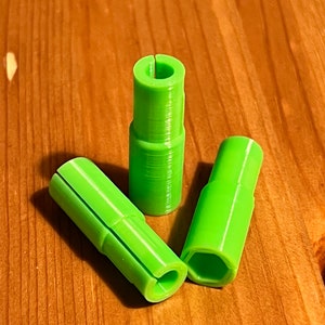 May include: Three lime green plastic connectors with different shapes. The connectors have a smooth, slightly textured surface.