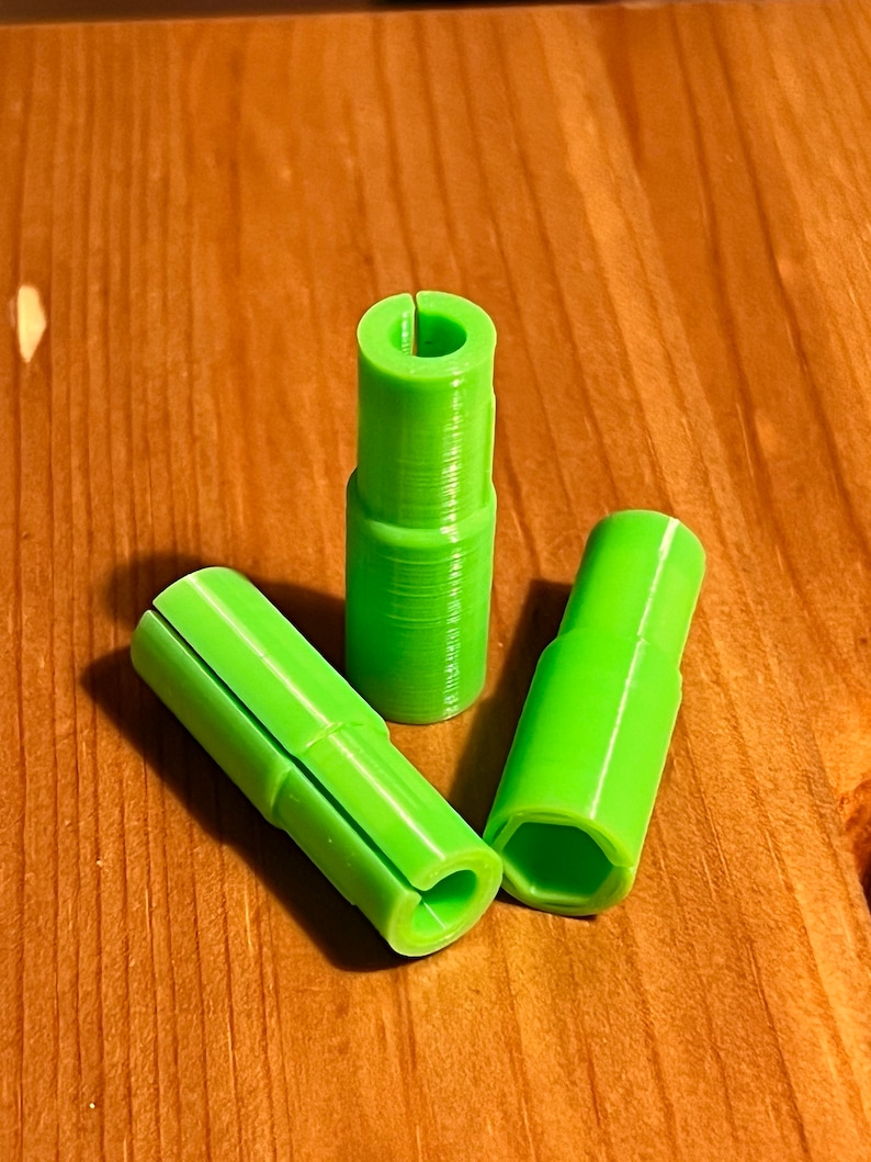 May include: Three lime green plastic connectors with different shapes. The connectors have a smooth, slightly textured surface.