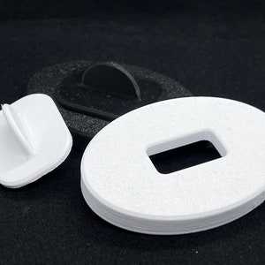 May include: Three white plastic pieces, one is a square with a small raised tab, another is a round piece with a rectangular hole, and the last is a round piece with a raised tab.