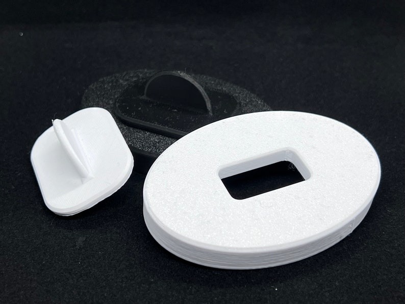 May include: Three white plastic pieces, one is a square with a small raised tab, another is a round piece with a rectangular hole, and the last is a round piece with a raised tab.