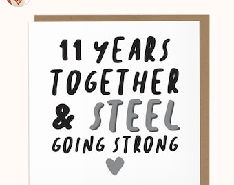 May include: A white card with black and gray text that reads "11 years together & steel going strong" with a gray heart at the bottom.