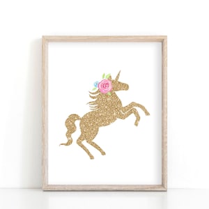 May include: A gold glitter unicorn silhouette with a pink and blue flower crown on a white background in a light wood frame.