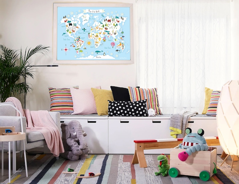May include: A white, wooden storage bench with three drawers and a colorful striped rug in front of it. There are several colorful pillows on the bench, including a pink, a yellow, and a black and white polka dot pillow. A stuffed elephant sits on the floor next to the bench. A world map with animals and landmarks is hanging on the wall behind the bench.