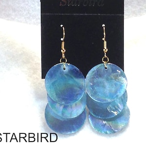 May include: A pair of blue iridescent shell earrings with gold hooks. The earrings are layered with three shells each.