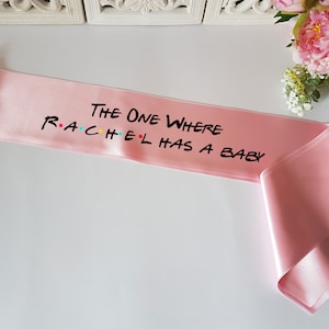 The one where custom has a baby showe sash with pin for Friends theme baby shower party