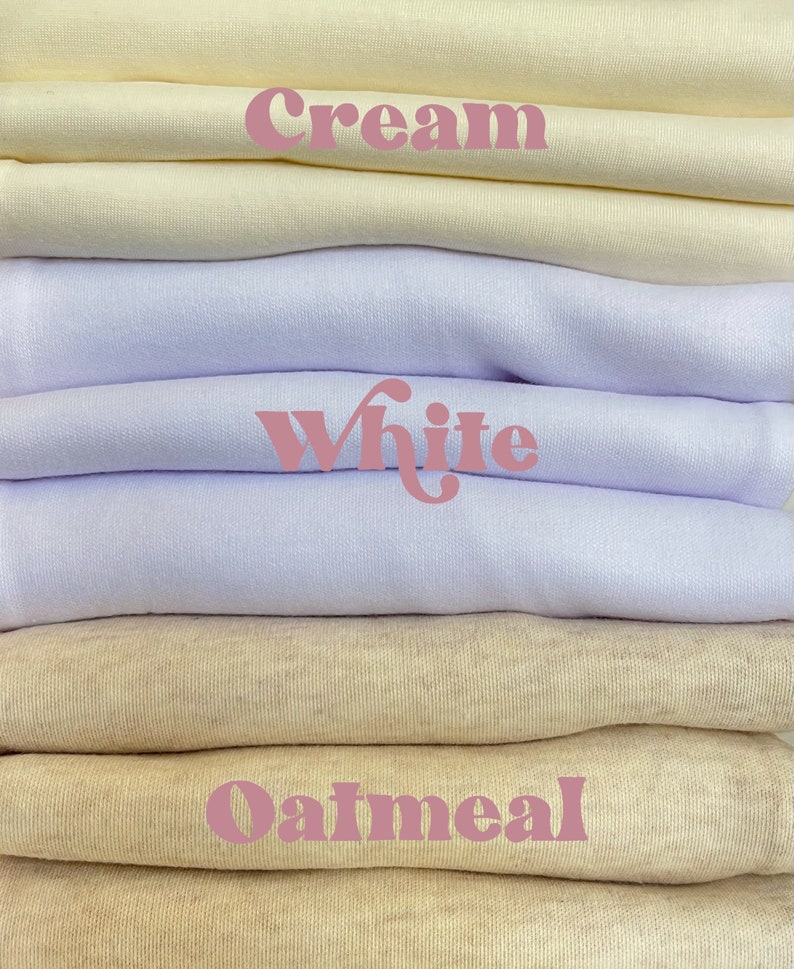 Puede incluir: Una pila de muestras de tela en color crema, blanco y avena. Los colores est&aacute;n etiquetados con las palabras "Crema", "Blanco" y "Avena".