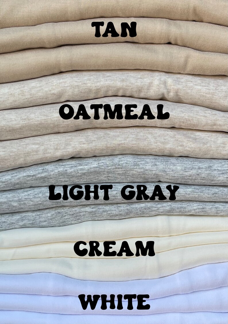 May include: A stack of folded fabric in five different colors: tan, oatmeal, light gray, cream, and white. The colors are labeled with black text.