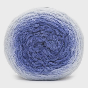 May include: A ball of yarn with a gradient of colors, transitioning from light blue to a deep indigo. The yarn has a soft, velvety texture, ideal for knitting or crocheting projects. The ball is round and tightly wound.