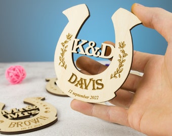 May include: A wooden horseshoe with the initials "K&D" and the surname "DAVIS" engraved on it. The date "12 September 2022" is also engraved on the horseshoe.