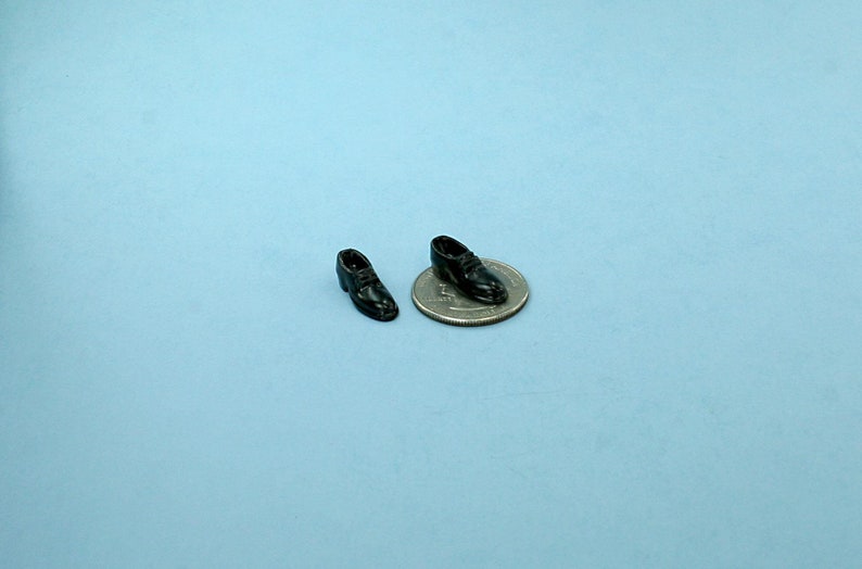 A great pair of dollhouse miniature men's dress shoes.
Not made to be worn by dolls, made of solid metal, painted black, they measure 5/16" wide x 3/4" long.