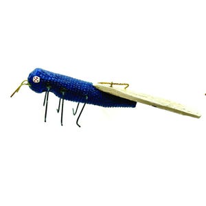 May include: Blue and white grasshopper ornament with a textured surface and a gold string for hanging.