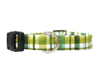May include: Green and yellow plaid dog collar with a black plastic buckle and a silver metal D-ring.