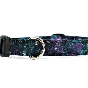 May include: A teal and purple patterned dog collar with a black plastic buckle and a silver D-ring.
