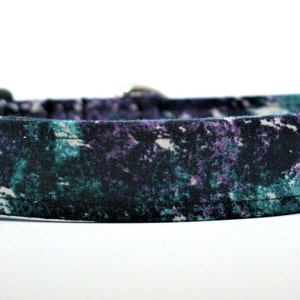 May include: A black dog collar with a purple and green tie-dye pattern.