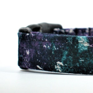May include: A black dog collar with a teal and purple abstract print.