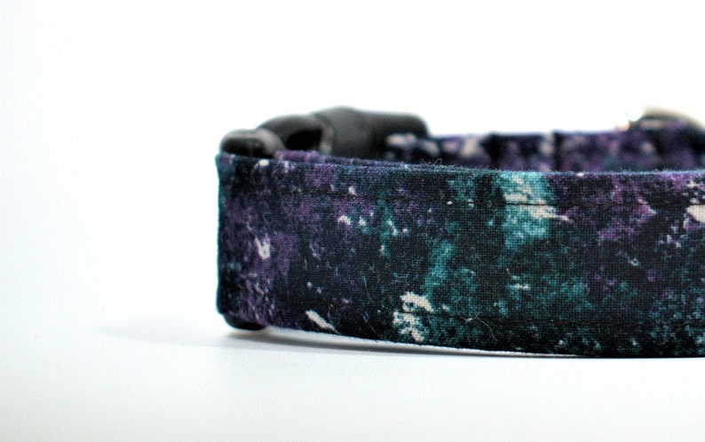 May include: A black dog collar with a teal and purple abstract print.