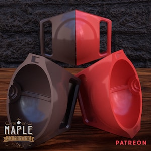 May include: Three 3D printed objects, two are red and one is brown. The objects are shaped like a half sphere with a handle on the side. The objects are sitting on a wooden surface. The text "MAPLE 3D PRINTING" is visible on the brown object. The text "PATREON" is visible on the wooden surface.