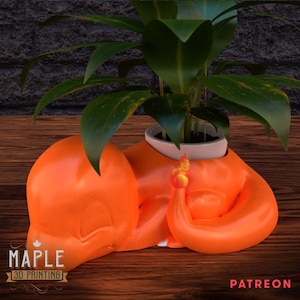 May include: Orange 3D printed planter shaped like a cartoon character with a plant inside. The planter is designed to look like a character with a curled up leg and a hand holding a flame. The planter is on a wooden surface. The text "MAPLE 3D PRINTING" and "PATREON" are visible in the image.