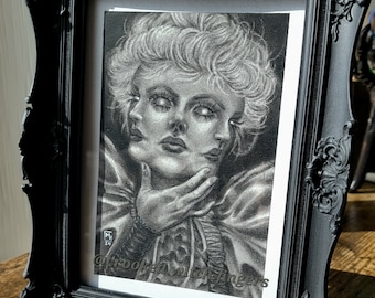 May include: Black and white drawing of a woman with three faces, framed in a black ornate frame. The drawing is signed "@crookedwitchfingers".