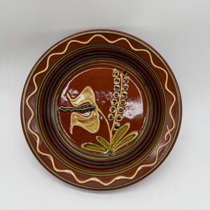 Puede incluir: Un juego de tres tazas de cerámica con un acabado mate moteado. Las tazas son en tonos crema, gris claro y gris oscuro. Cada taza tiene un diseño simple y minimalista y un asa redondeada. Para café o té.