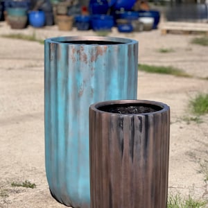 May include: Two decorative planters, one teal blue and one brown, with a textured, ribbed design. The planters are made of a durable material and are perfect for adding a touch of rustic elegance to any home or garden.