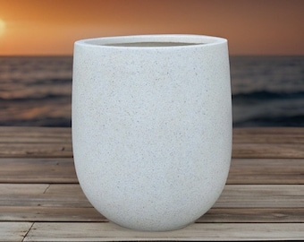 May include: White ceramic planter with a speckled finish. The planter has a rounded, cylindrical shape and a smooth, matte surface.