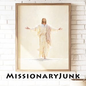 May include: Framed print of a figure with long hair and a beard, wearing white robes and a pink sash, arms outstretched. The artwork is set against a light background. The text "MISSIONARYJUNK" is printed at the bottom.