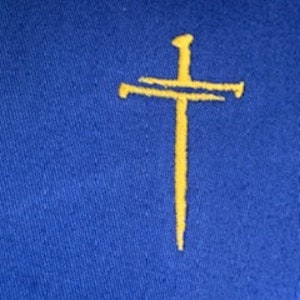 May include: A blue fabric patch with a yellow embroidered cross and nail.