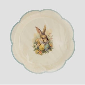 May include: A white paper party plate with a blue scalloped edge features a vintage illustration of a brown rabbit holding Easter eggs. The rabbit is surrounded by yellow and blue flowers.