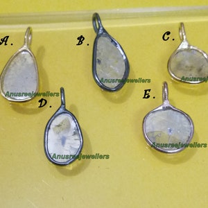 Op de afbeelding: Vijf verschillende hangers, elk met een heldere, gefacetteerde edelsteen met een uniek patroon. De hangers zijn allemaal gemaakt van goud of zilver en hebben een eenvoudig, elegant ontwerp.