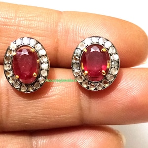 Puede incluir: Un par de pendientes de rubí y diamantes. Los pendientes son de forma ovalada y están engastados en plata con un halo de pequeños diamantes. Los rubíes son de color rojo intenso.