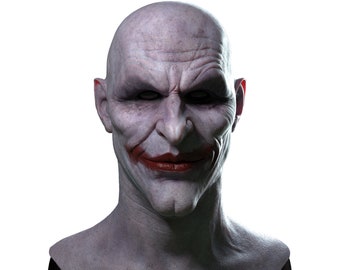 May include: A close-up of a bald, pale-skinned man's head with a sinister smile. His lips are painted red, and his eyes are dark and intense. The man's head is on a black stand.