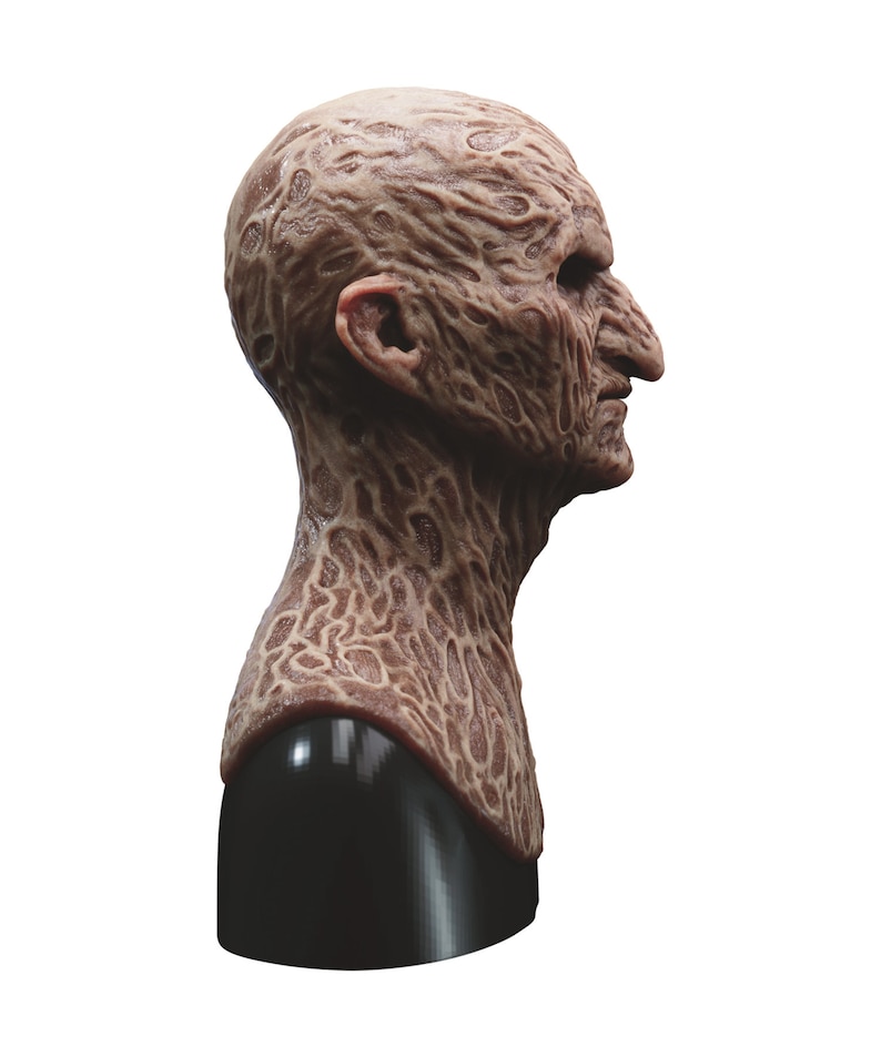 May include: A detailed, realistic, and disturbing latex mask of a burned human face. The mask is sculpted with intricate details of burned skin and is mounted on a black stand.