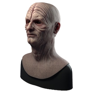 May include: A detailed bust sculpture of a fictional character with wrinkled skin and a serious expression. The bust is mounted on a black base.