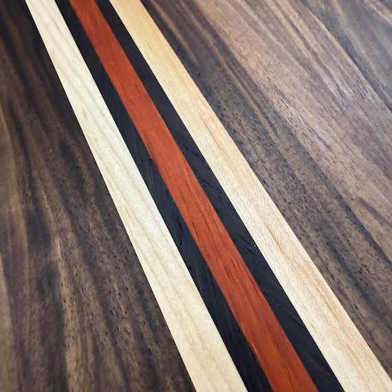 Walnut, maple, padauk and wenge edge grain cutting board